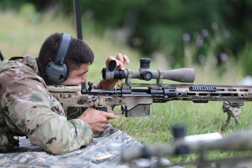 Spc. Richard Spinella, an infantryman assigned to the New York Army National Guard's 2nd Battalion, 108th Infantry Regiment sniper section, adjusts the zoom of a scope on the XM2010 Enhanced Sniper Rifle during marksmanship training at Fort Drum, New York