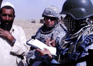 New York Army National Guard Col. Mark Heffner, center, speaks with Khvajeh Ghar Village elder Khan Mohamed, far left, about possible assistance the civil affairs team out of Camp Alamo and the Training Assistance Group can offer. At right, an Afghan interpreter helps bridge the language barrier between the two. Heffner is the TAG commander. (Photo courtesy MPRI/G. A. Volb)