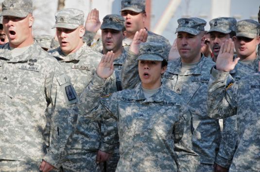New York Army National Guard Major General Patrick Murphy, The Adjutant General of New York, coins a National Guard Airmen during a reenlistment ceremony held at the World Trade Center Memorial on Veterans Day, Nov. 11, 2012.