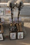 Friends of the late Staff Sgt. Andrew Seabrooks and Spc. Anthony L. Mangano place unit patches, name tapes and a beret with the unit crest of the 1st Battalion 258th field Artillery � their former unit on the boots of the Fallen Warrior display.
