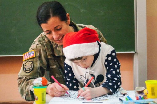 New York Army National Guard Major Amy Crounse, member of the 27th Infantry Brigade Combat Team deployed to Ukraine, spends time with a child at the orphanage in Krakovets, Ukraine on Dec. 27. During the visit, Soldiers brought games and toys to give to t