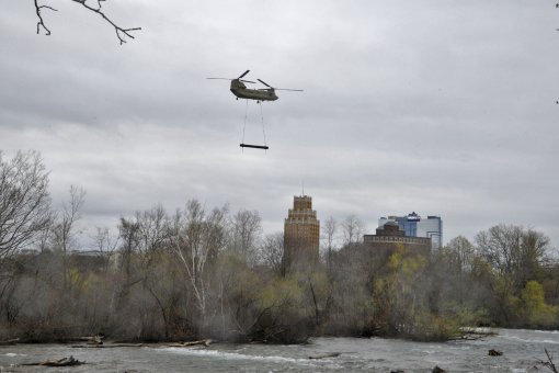 A CH-47 Chinook assigned to the New York Army National Guards Bravo Company 3rd Battalion 126th Aviation removes a 3900-pound steel pontoon from the Niagara River just above the American side of Niagara Falls in Niagara Falls New York on May 4 2022. The p
