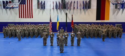 GRAFENWHOEHR, Germany- New York Army National Guard Soldiers from Task Force Orion and Arkansas Army National Guard Soldiers from Task Force Bowie, stand at attention during a ceremony in which authority for the Joint Multinational Training Group-Ukraine 