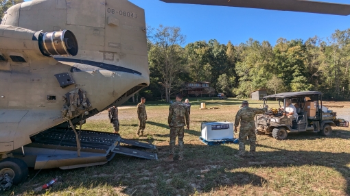 GREEN RIVER, North Carolina-- Local residents use an all terrain vehicle to unload supplies from a CH-47F Chinook helicopter flown by Soldiers assigned to B Company, 3rd Battalion, 126th General Support Aviation Battalion, in Green River, North Carolina, 