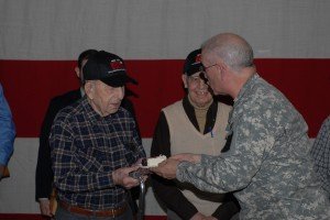 LATHAM, NY--92-year old World War II veteran John Sidur, who fought with the New York National Guard&rsquo;s 27th Division on Okinawa and Saipan, gets the first piece of National Guard Birthday Cake from New York National Guard Command Sgt. Major Robert Van Pelt during a Guard Birthday ceremony at New York State Division of Military and Naval Affairs headquarters on Monday. Dec. 13.