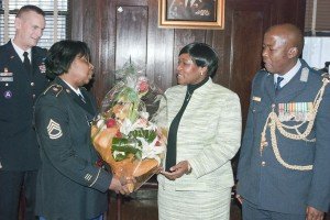 NEW YORK--Major General Patrick Murphy, the Adjutant General of New York,looks on as Sgt 1st Class Sandra Moody, presents a boquet to Matshipo Phala, the wife of Brig. Gen. Mashoro Phala, the South African Defense Attache to the United States (right) during a ceremony held  at the Lexington Avenue Armory here on Dec. 18  to mark the 10th anniversary of the State Partnership Program relationship between the New York National Guard and the South African National Defense Force .