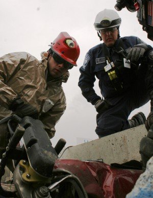 Bob Reardon of the Federal Emergency Management Agency&rsquo;s Urban Search and Rescue Team (right) shows Spc. Joshua Poitras, Massachusetts Army National Guard CERFP member (left) how to use the jaws of life to cut up a car at the Spaulding Fibre site in Tonawanda during Exercise Vigilant Guard on Tuesday. Massachusetts National Guard troops and FEMA personnel taking part in the exercise also practiced rescuing mock casualties from the simulated earthquake disaster area, or rubble pile, located at the site.
Photo by Staff Sgt. Raymond Drumsta, 138th Public Affairs Detachment