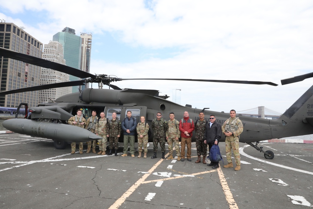 
                A Brazilian delegation and New York National Guard Soldiers and Airmen pose for a photograph at a Manhattan heliport as they prepare to board a New York Army National Guard UH-60M Black Hawk helicopter assigned to the 3rd Battalion, 142nd Aviation Regiment, for a flight to Fort Indiantown Gap, Pennsylvania on April 18, 2023. The Brazilians were heading to the Pennsylvania base to observe the New York National Guard Chemical Biological Radiological and Nuclear response team conducting a training exercise. The Brazilians were visiting New York as part of the New York National Guard's State Partnership Program relationship with that nation's military.            