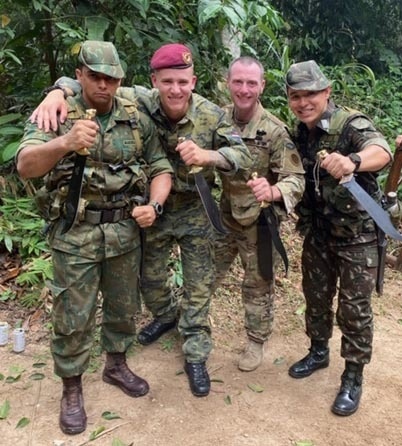 
                New York Army National Guard Staff Sgt. Thomas Carpenter, second from right, and other Soldiers who graduated from the Jungle Operations International Course conducted by the Brazilian Army Jungle Warfare Training Center, brandish their machetes following a graduation ceremony on Nov. 30, 2019 in Manaus, Brazil. Carpenter was the 30th American Soldier to graduate from the tough, demanding course. (Courtesy photo)            