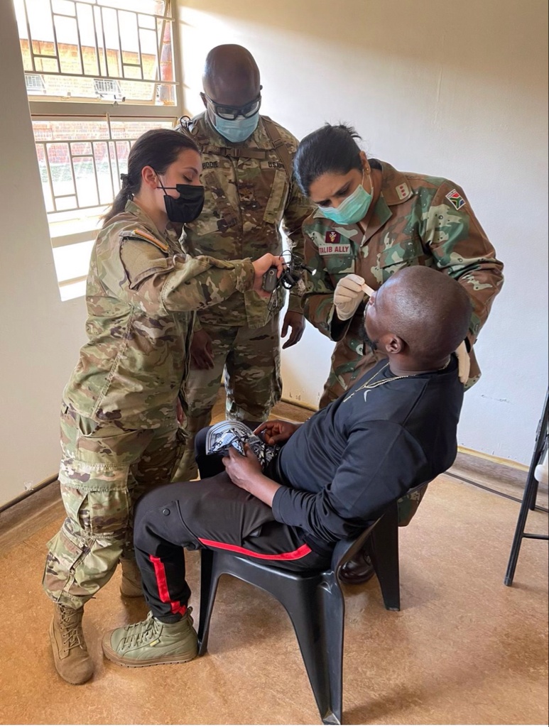 
                New York Army National Guard Staff Sgt. Christine Iraci, left, and Army Reserve Major Dwayne Bodie, look on as South African Military Health Service Anissa Talib-Ally checks a patient outside Richards Bay, South African during a medical readiness visit conducted on July 25, 2022, as part of Exercise Shared Accord. The every-other-year exercise teams American military personnel with those from an African nation. This year’s exercise includes joint U.S.Army-South African National Defense Force medical outreach missions to local communities, as well as tactical training. (Courtesy photo)            