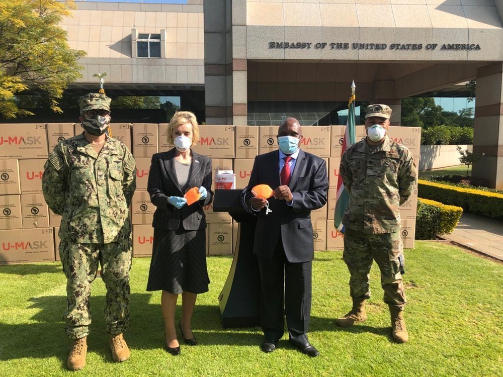 
                Lana. J.Marks, center left, the United States Ambassador to South Africa, joins South African Deputy Health Minister Dr. Joe Phaala, center right, in marking the delivery of 720,000 FFP2 protective masks to to South Africa's National Department of Heatlh from the U.S. Department of Defense Threat Reduction Agency’s (DTRA) Biological Threat Reduction Program at the U.S. Embassy in Pretoria, South Africa on May 15, 2020. Also pictured are U.S. Navy Capt. Steven Morgenfeld, the Senior Defense Attache at the U.S. Embassy, far left, and Lt. Col. Darrick Mosley, the U.S. Office of Defense Cooperation Chief in South Africa. Photo by Army Lt. Col. Al Phillips, U.S. Embassy Pretoria.            
